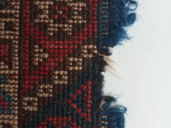 Lisière rompue et franges arrachées.